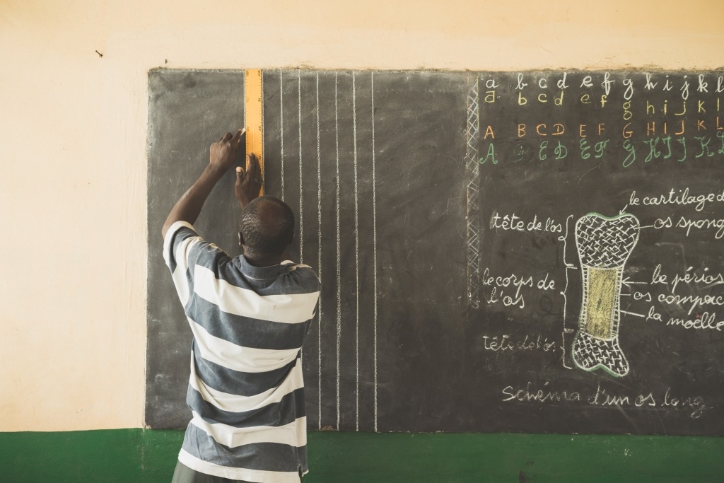 Teacher at a village school in rural Togo preparing for his class. By Jordan Rowland (CC0) via Unsplash. https://unsplash.com/photos/eAiNt7N5FaA