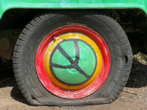 Travellers, tourists, and tourism for peace ... Picture of flat tyre with peace sign hub cap by Charles Pickrell (CC0) via Unsplash.